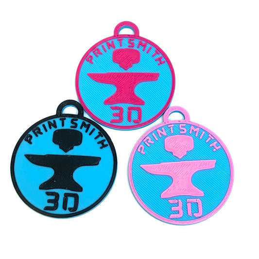 3 examples of PrintSmith 3D's custom keychains using PrintSmith 3D's logo one in light blue and black, one in light blue and light pink, and one in light blue and hot pink